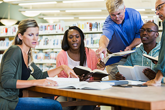 Adults looking at books in a library